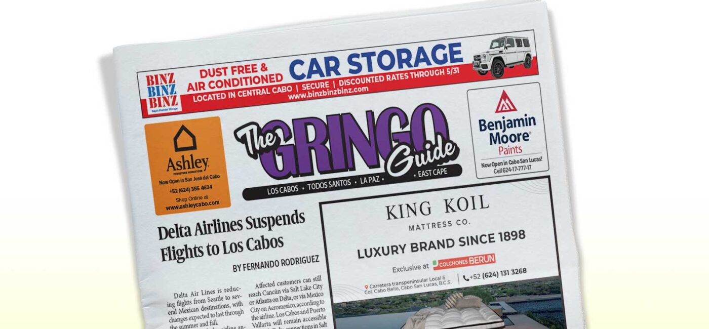 Tilted newspaper front page showing 'The Gringo Guide' masthead with ads and a Delta Airlines article headline reading 'Delta Airlines Suspends Flights to Los Cabos'