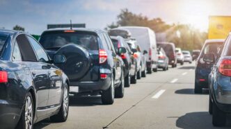 Line of cars bumper-to-bumper on a crowded highway during daytime.