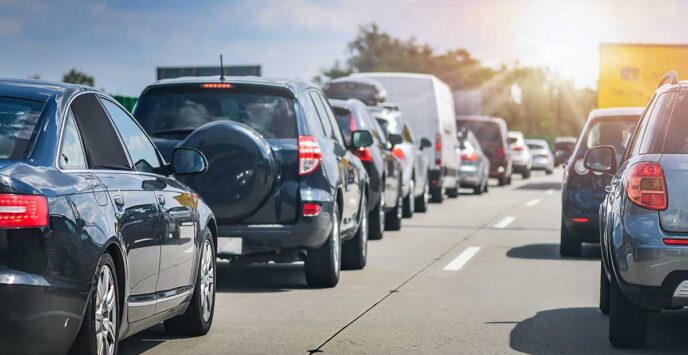Line of cars bumper-to-bumper on a crowded highway during daytime.
