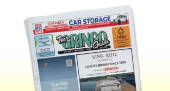 Tilted newspaper front page with The Gringo Guide masthead and various ads, including King Koil mattress and Ashley furniture logos.
