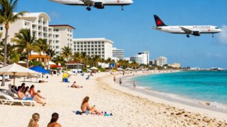 Air-Canada - Gringo Gazette Two Air Canada airplanes fly low over a sunny tropical beach with sunbathers and palm‑lined hotels along the shore.