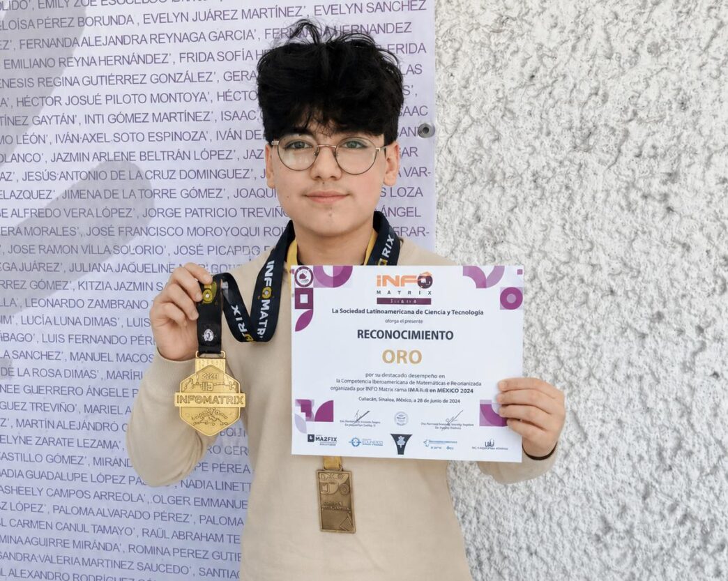 Person holding a certificate that says "RECONOCIMIENTO ORO" with two medals hanging from their necks against a textured wall background, facing camera.