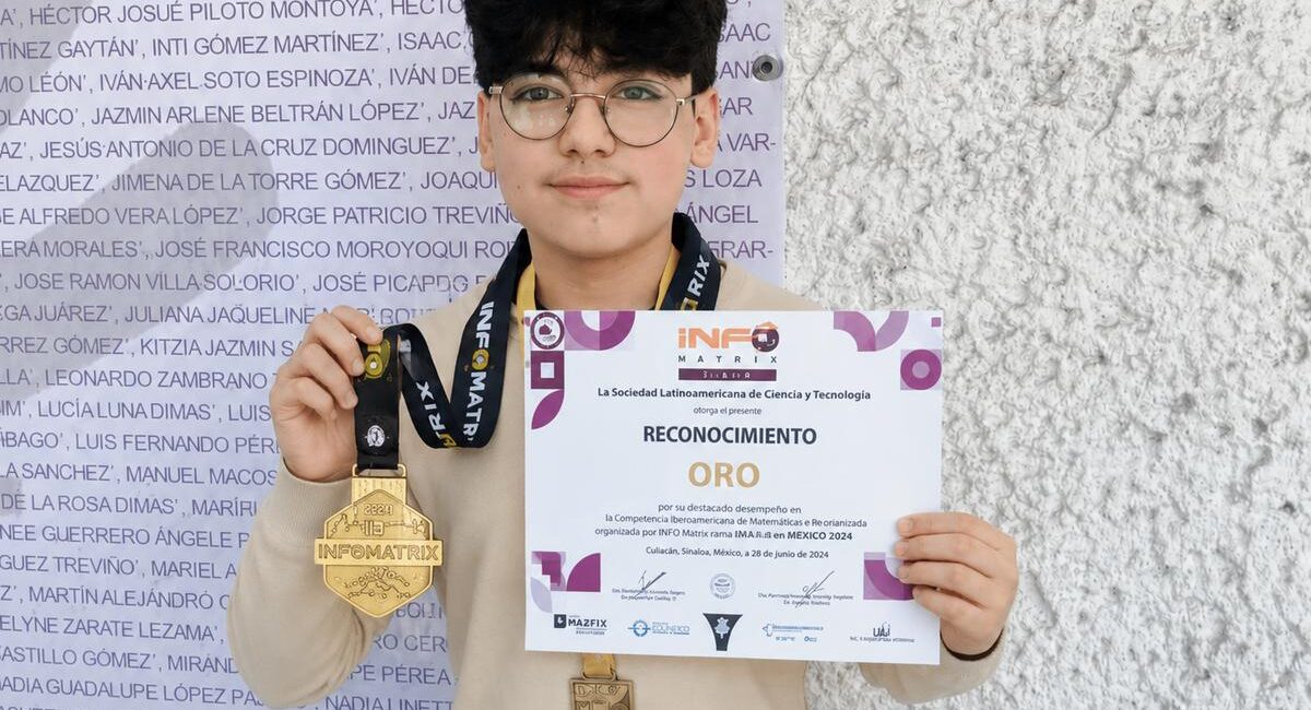 Person holding a certificate that says "RECONOCIMIENTO ORO" with two medals hanging from their necks against a textured wall background, facing camera.
