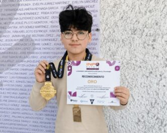 Person holding a certificate that says "RECONOCIMIENTO ORO" with two medals hanging from their necks against a textured wall background, facing camera.