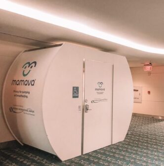 White Mamava privacy pod for pumping or breastfeeding in a hallway.