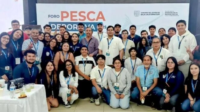 Large group of attendees posing for a photo at Foro Pesca Deportiva, wearing lanyards, with the event banner in the background.