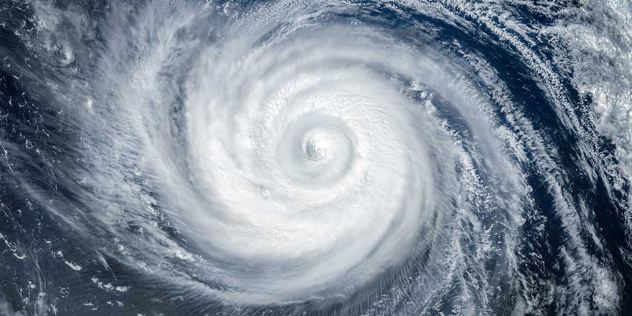Satellite image of a powerful hurricane with a clearly defined eye and spiraling rain bands over the ocean.