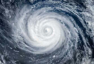 Satellite image of a powerful hurricane with a clearly defined eye and spiraling rain bands over the ocean.