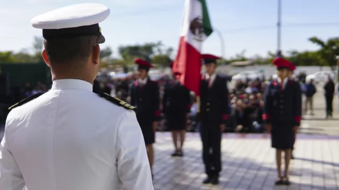 La Paz Names Navy Officer as New Police Chief - Gringo Gazette Back view of a white-dress military officer addressing a line of cadets at a ceremony, with a Mexican flag in the background.