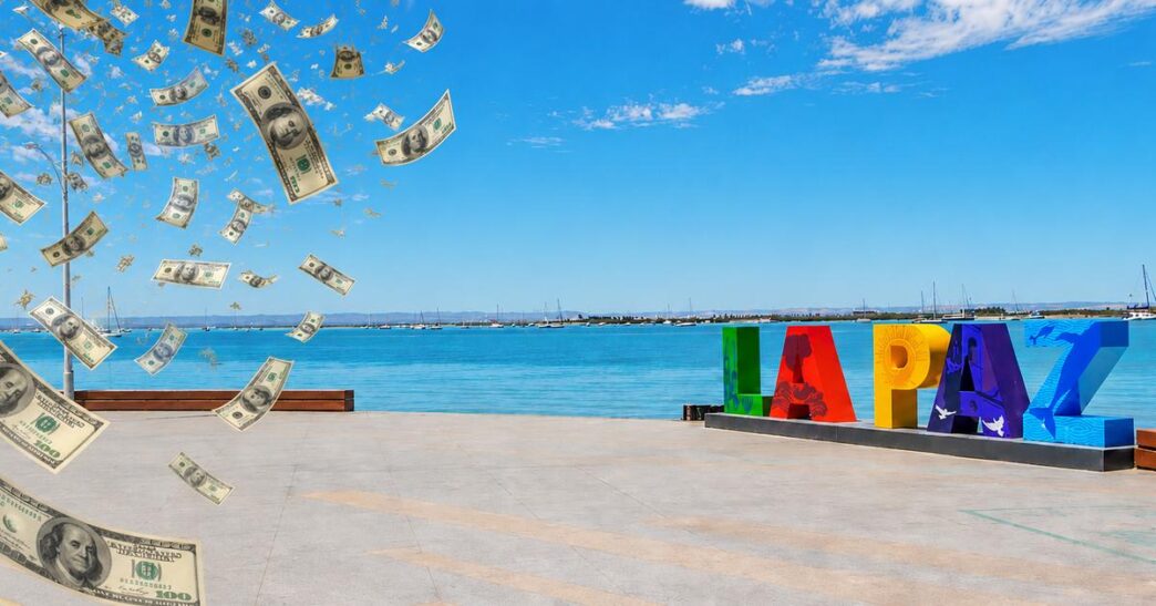 Colorful LAPAZ sign on a waterfront promenade as fake money rain falls over the scene by the blue sea and sky.