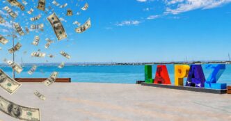 Colorful LAPAZ sign on a waterfront promenade as fake money rain falls over the scene by the blue sea and sky.