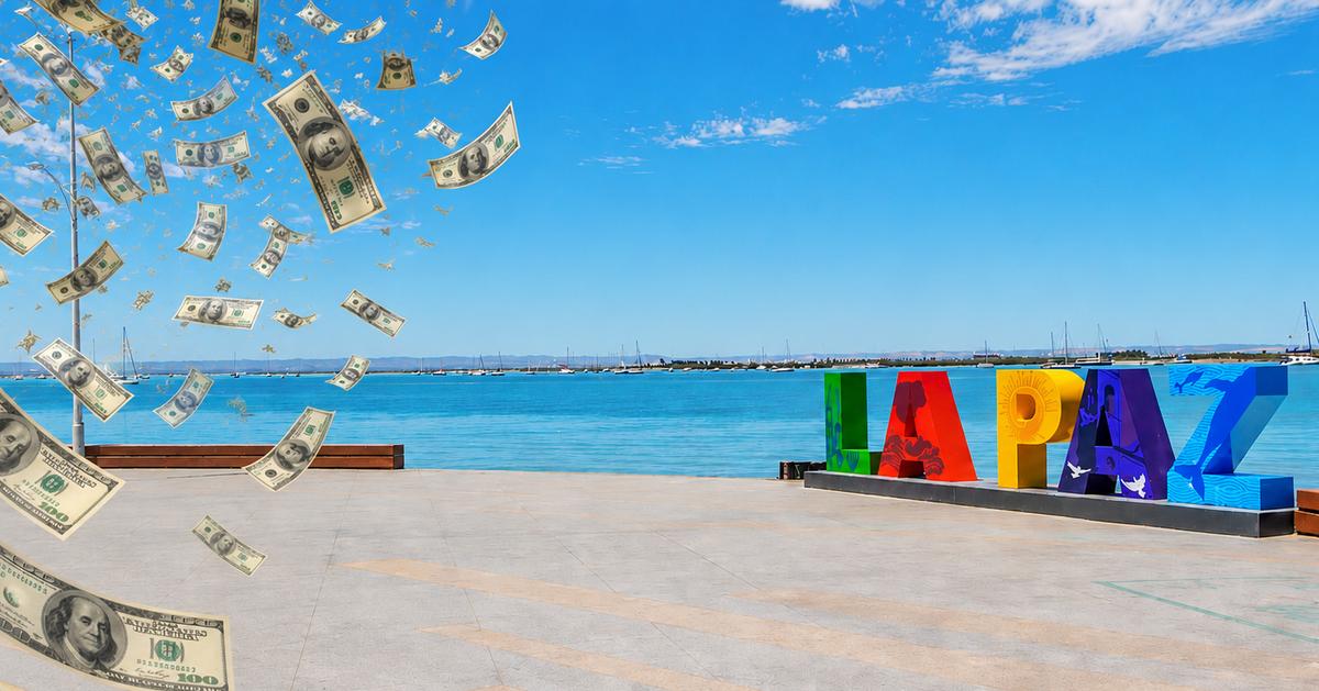 Colorful LAPAZ sign on a waterfront promenade as fake money rain falls over the scene by the blue sea and sky.