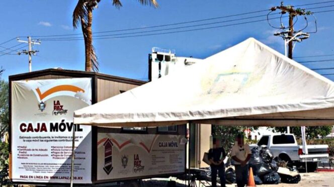 Mobile bank truck labeled Caja Móvil under a white canopy, with a palm tree and people nearby.