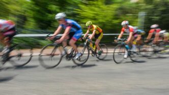tourFrance - Gringo Gazette Group of cyclists racing on a road, motion blur showing high speed and forward motion.