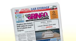Tilted front page of a newspaper titled The Gringo Guide with a bold pink-and-black masthead, featuring a large headline about pediatric heart surgeries and surrounding ads and images,set against a light background.