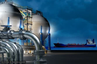 Industrial facility with large spherical storage tanks and extensive piping beside a dock.
