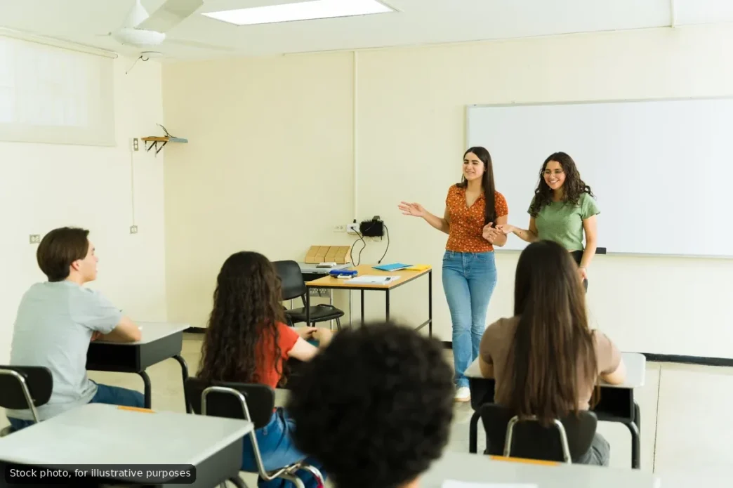 Los Cabos Schools Closed Tuesday After Heavy Rain - Gringo Gazette Two young women present at the front of a classroom while peers sit at desks and listen near a whiteboard.
