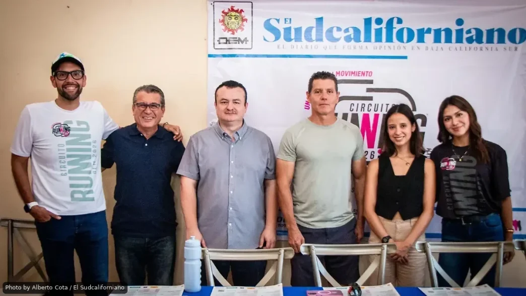 Six people stand side by side at a press event in front of a banner reading 'El Sudcaliforniano'.