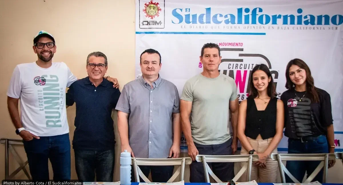Six people stand side by side at a press event in front of a banner reading 'El Sudcaliforniano'.